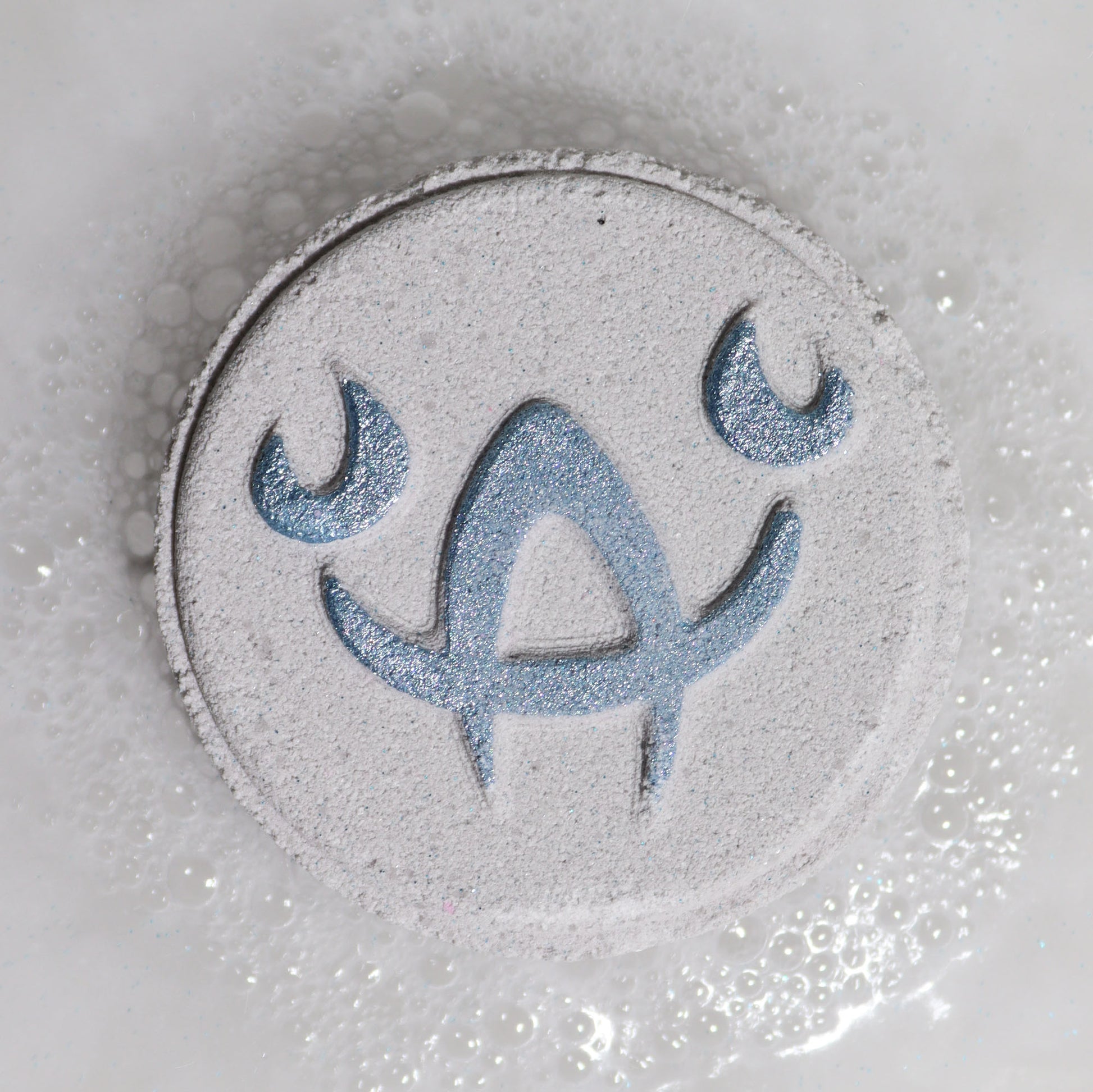 Close-up of Cancer bath bomb fizzing with soft pastel tones and calming floral fragrance