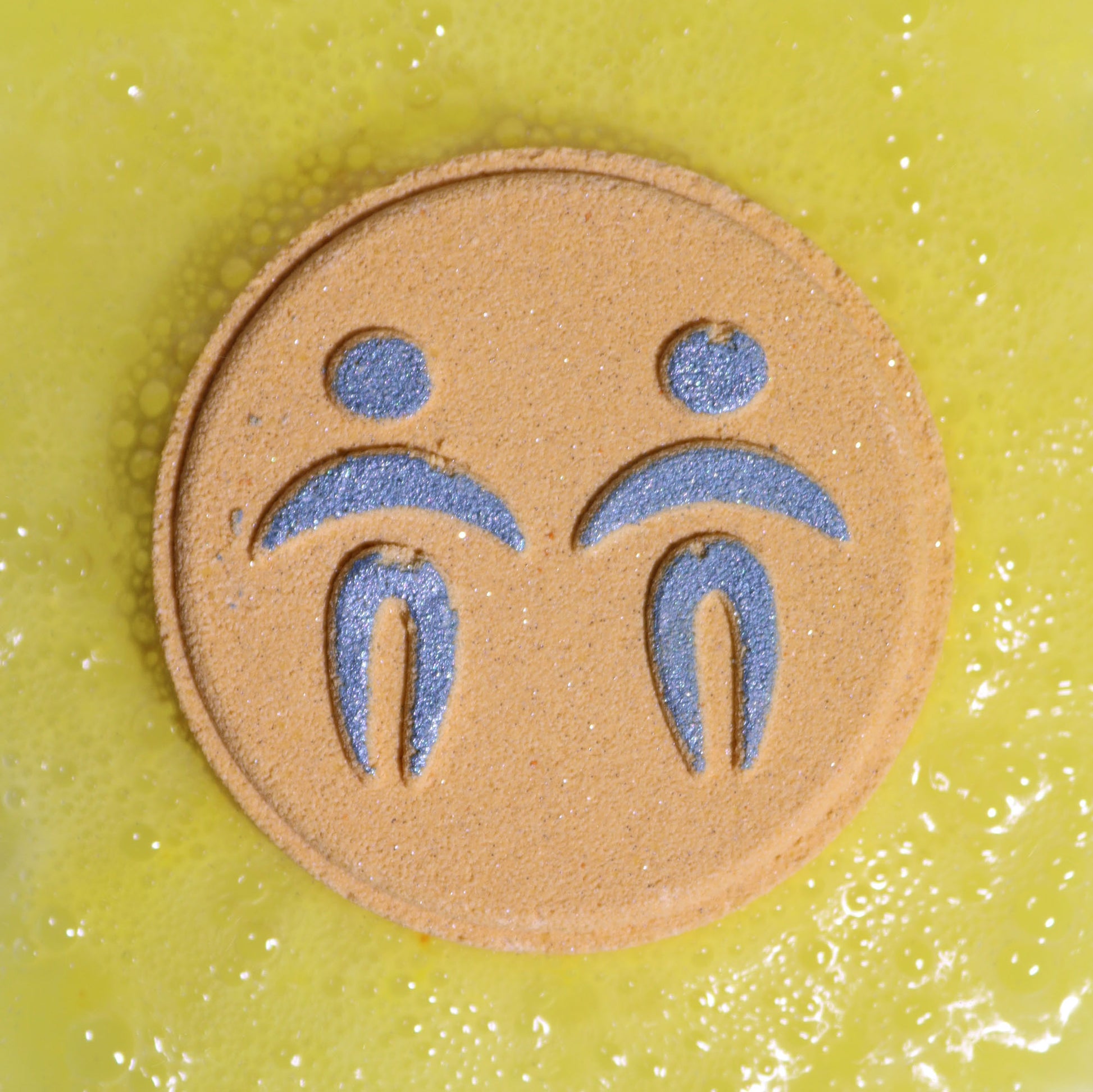 Close-up of Gemini bath bomb fizzing with bright colours and lively citrus fragrance