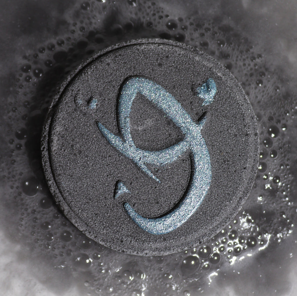 Close-up of Scorpio bath bomb fizzing in water with rich, dark colours and mysterious spicy fragrance